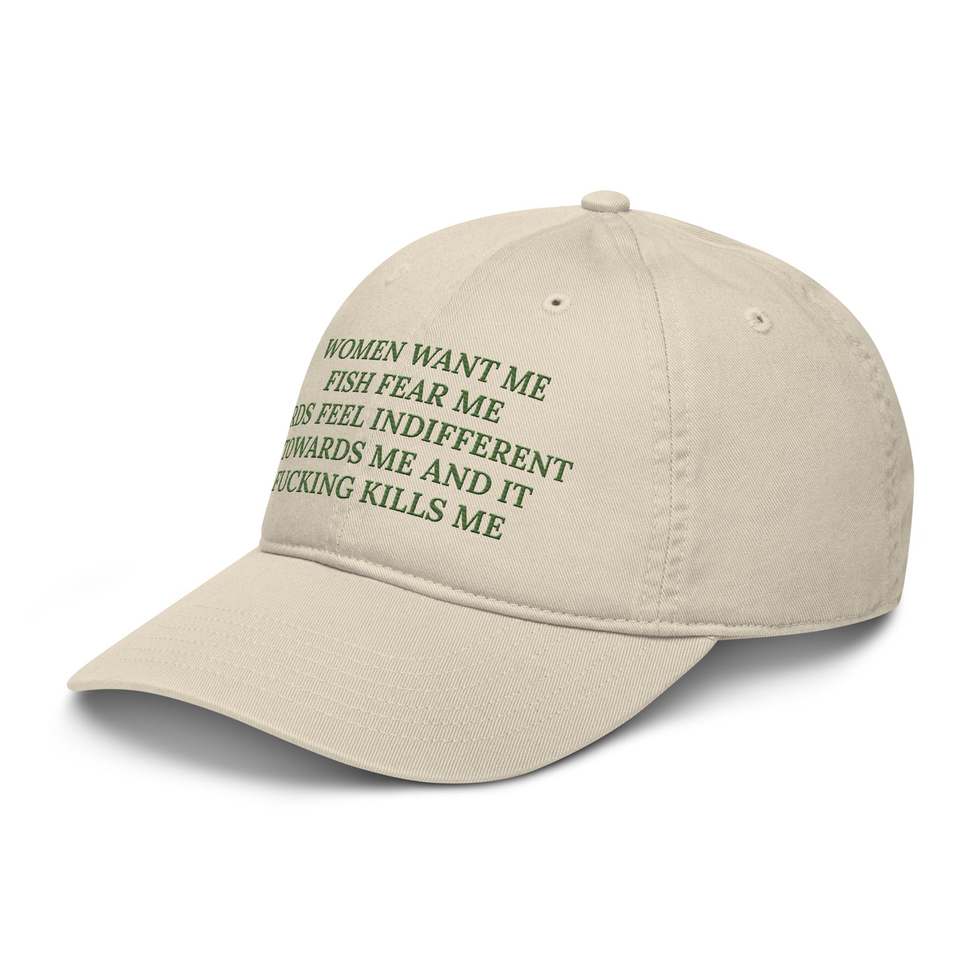 A side angle of the beige baseball cap with the text women want me fish fear me birds feel indifferent towards me and it fucking kills me in green embroidered text